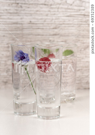strong alcohol drink with mint and raspberry in high glass strong alcohol drink with mint and raspberry in high glass 69352389