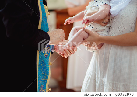 Orthodox baptism. priest puts crosses brush in oil 69352976