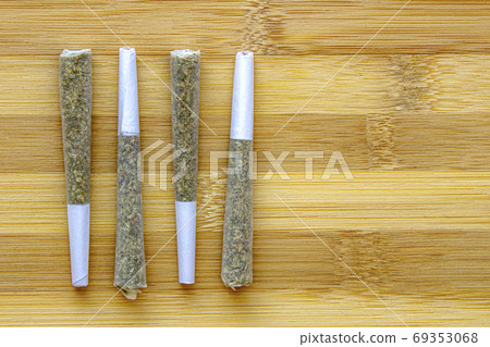 Several Legal Canadian Pre-Rolls Cannabis Joints on a wooden surface. 69353068