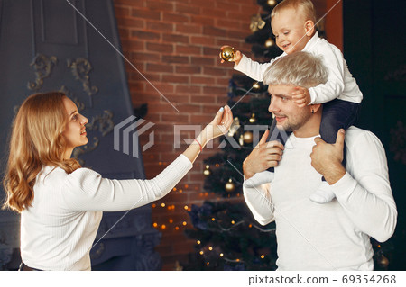 Family with little son at home near christmas tree Family with little son at home near christmas tree 69354268