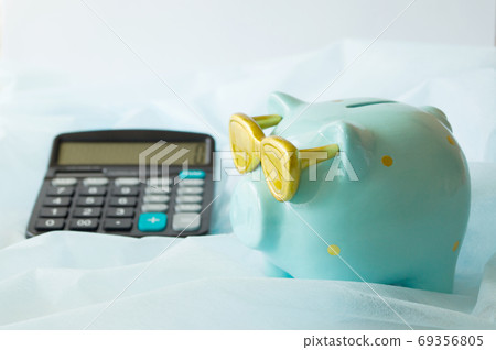 Piggy Bank aquamarine color and calculator. The concept of saving money and planning a financial budget. Piggy Bank aquamarine color and calculator. The concept of saving money and planning a financial budget. 69356805