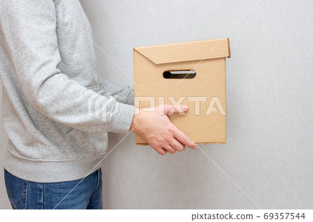 Courier with a parcel in his hands. Delivery concept. Cardboard box 69357544