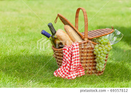 Picnic basket with wine, baguette and grapes 69357812