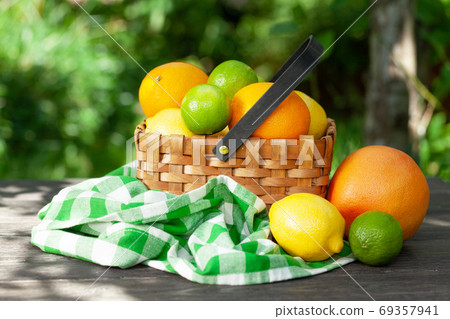 Variuos citrus fruits in basket on garden table Variuos citrus fruits in basket on garden table 69357941
