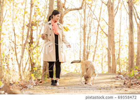 Woman and dog in autumn nature 69358472