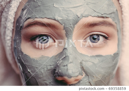 Macro shot woman face with clay facial mask on face isolated, clos up, macro Macro shot woman face with clay facial mask on face isolated, clos up, macro 69358859