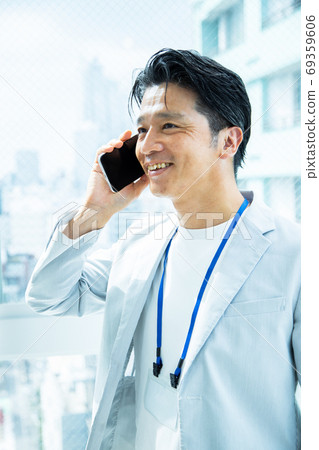 Male office worker calling on a smartphone Male office worker calling on a smartphone 69359606
