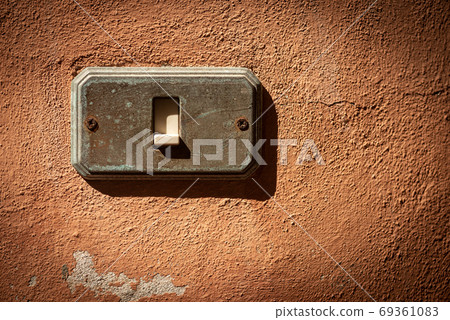 Old and rusty Light Switch on a red wall - Liguria Italy Old and rusty Light Switch on a red wall - Liguria Italy 69361083