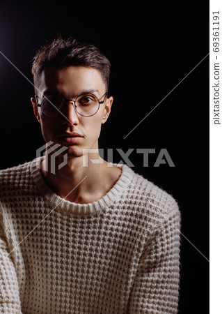 Studio shot of a handsome young male model wearing white T-shirt and sunglasses 69361191