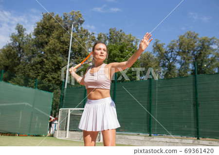 Beautiful female tennis player serving outdoor 69361420