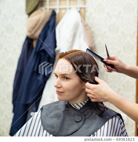 combing wet hair after shampooing before haircut. combing wet hair after shampooing before haircut. 69361623