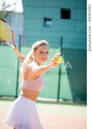 Woman serving the ball for a game of tennis on court 69362091