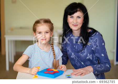 a teacher and girl solve mathematical puzzle. a teacher and girl solve mathematical puzzle. 69362785