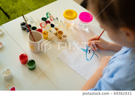 girl drawing with brush and paints top view girl drawing with brush and paints top view 69362831