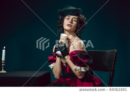 Young woman as Anna Karenina on dark blue background. Retro style, comparison of eras concept. 69362891