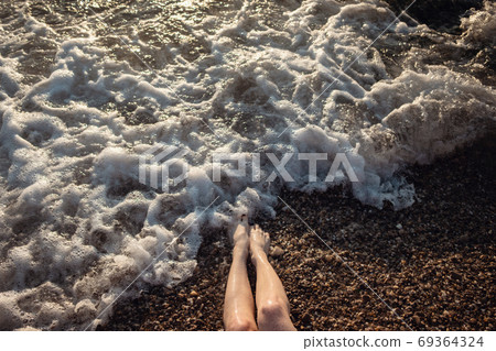 Happy woman wearing bikini is playing and splashing in the sea Happy woman wearing bikini is playing and splashing in the sea 69364324