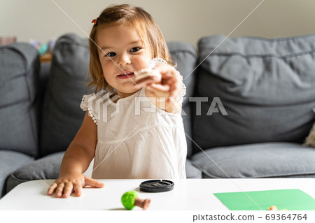 Caucasian toddler girl playing modeling play dough at home with mother. Homeschooling concept Caucasian toddler girl playing modeling play dough at home with mother. Homeschooling concept 69364764