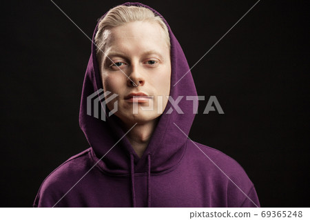 Sports fashion concept. Albino guy posing in sporty clothing isolated over black background. 69365248