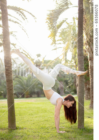 Attractive woman practicing fitness working out outdoors over nature background 69366078