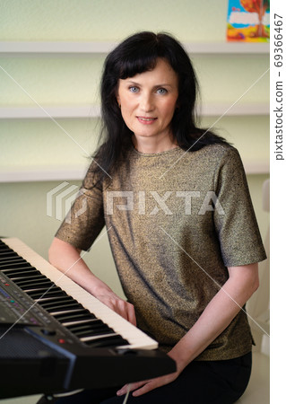 adult female sits at synthesizer in music class adult female sits at synthesizer in music class 69366467