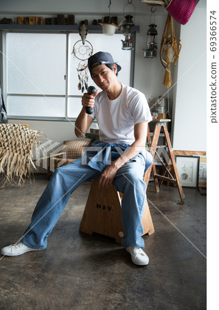Man with an electric screwdriver 69366574