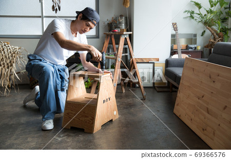 Man with an electric screwdriver 69366576