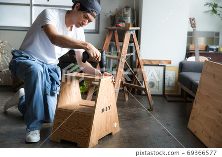 Man with an electric screwdriver Man with an electric screwdriver 69366577