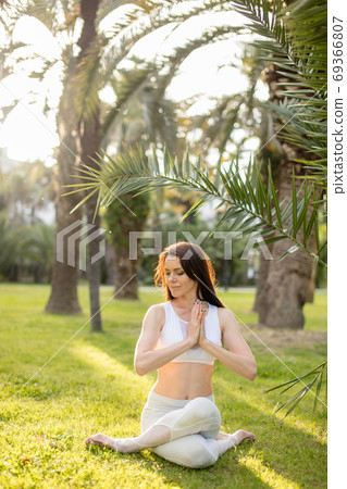 Fitness woman training yoga in cow head pose in nature background. 69366807