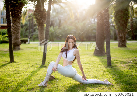 Yoga instructor giving masterclass in the open air at yoga park. 69366821