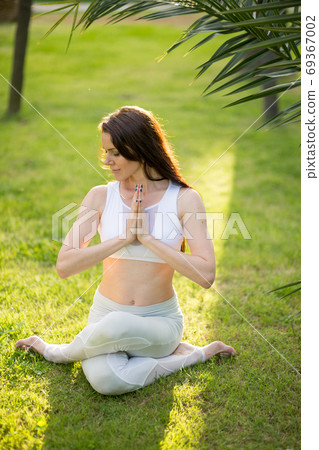 Fitness woman training yoga in cow head pose in nature background. 69367002