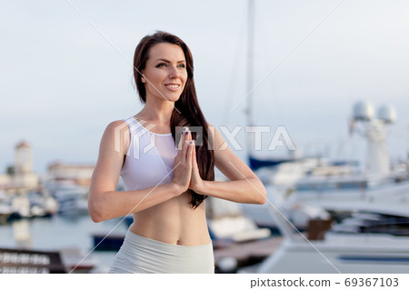 Woman working out outdoors, doing yoga exercise, Tree Pose at Navy Pier 69367103