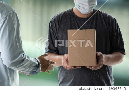 Delivery man holding cardboard boxes and accepting delivery man Delivery man holding cardboard boxes and accepting delivery man 69367243