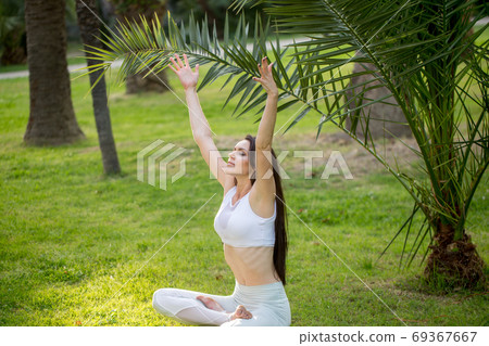 Yoga Woman meditating in lotus pose outdoor, park, garden, forest Yoga Woman meditating in lotus pose outdoor, park, garden, forest 69367667