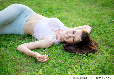 Joyful woman lying on green grass on park medow. Outdoors. Enjoy Nature. Joyful woman lying on green grass on park medow. Outdoors. Enjoy Nature. 69367669