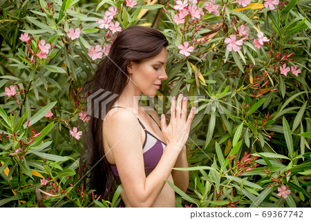 beautiful young woman practicing yoga in park and making namaste mudra 69367742