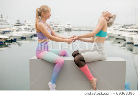Three woman have meditation on yoga class, outdoor on marine pier. 69368396