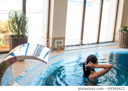 Calmness and harmony woman relaxing in spa swimming-pool Calmness and harmony woman relaxing in spa swimming-pool 69368422