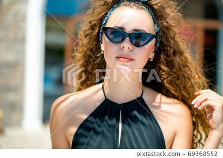 Beautiful woman enjoying the sunshine at a seaside cafe 69368552