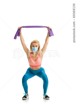 Beautiful female fitness coach practicing isolated on white studio background Beautiful female fitness coach practicing isolated on white studio background 69369130