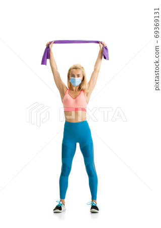 Beautiful female fitness coach practicing isolated on white studio background Beautiful female fitness coach practicing isolated on white studio background 69369131