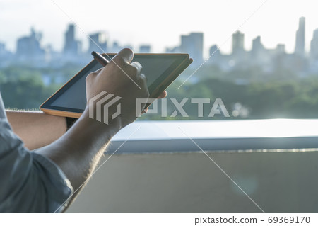 Business man hand written on tablet City Business man hand written on tablet City 69369170