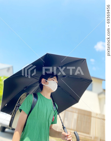 Elementary school students walking with a parasol in the heat of the heat 69369456