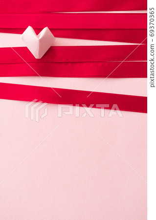 Pink origami heart and pink color satin ribbons on paper backgro Pink origami heart and pink color satin ribbons on paper backgro 69370365