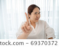 Asian plus size woman pointing with finger up and angry expressi 69370372