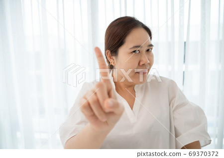 Asian plus size woman pointing with finger up and angry expressi Asian plus size woman pointing with finger up and angry expressi 69370372