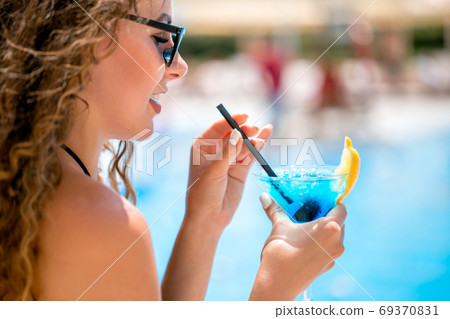 Beautiful woman enjoying the sunshine at a seaside cafe 69370831