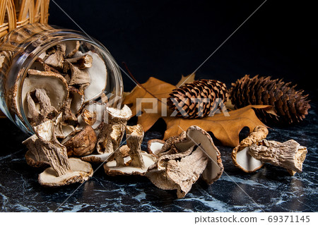 Dry wild mushrooms on black marble background. Dry wild mushrooms on black marble background. 69371145