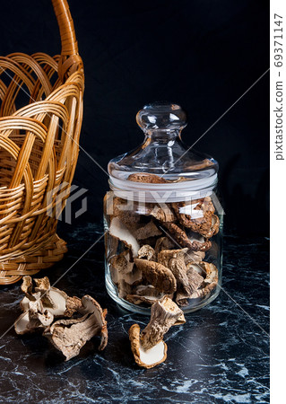 Dried wild mushrooms on black marble background. Dried wild mushrooms on black marble background. 69371147