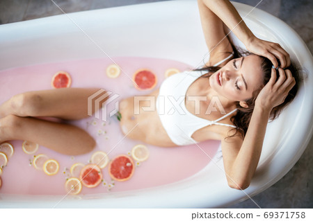 Woman relaxing in milky bath in spa resort. Wellness and Wellbeing concept Woman relaxing in milky bath in spa resort. Wellness and Wellbeing concept 69371758
