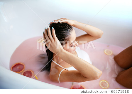 Woman relaxing in milky bath in spa resort. Wellness and Wellbeing concept Woman relaxing in milky bath in spa resort. Wellness and Wellbeing concept 69371918
